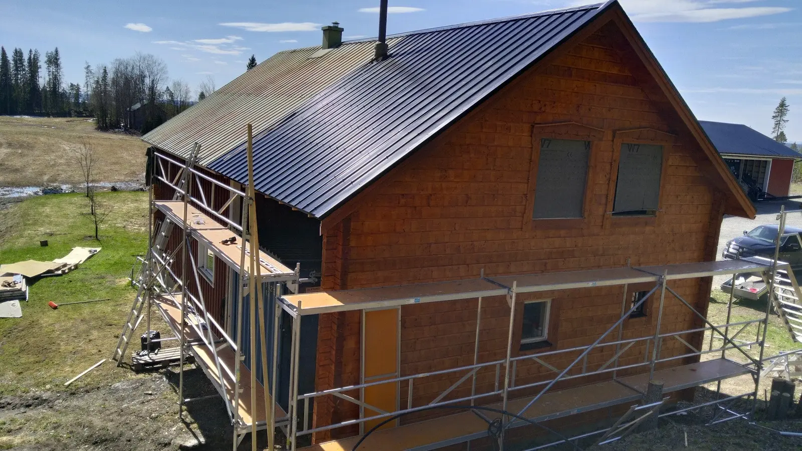 Exteriörbild av byggprojekt med träfasad och tak.