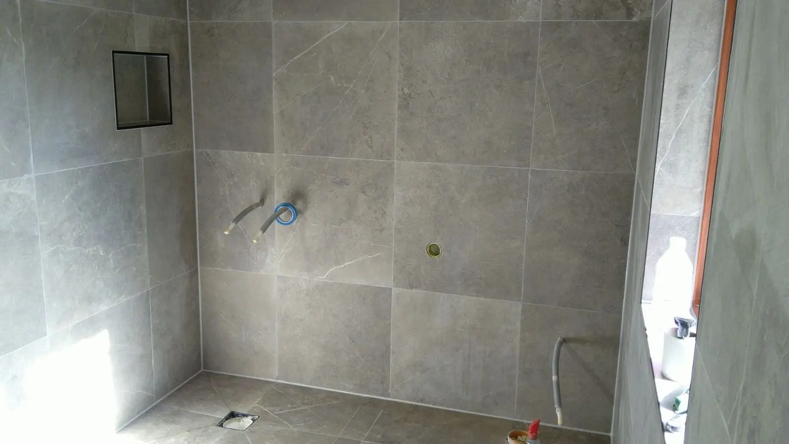 Badrumsinteriör med stora plattor.