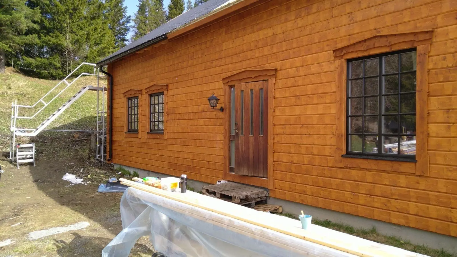 Träfasad med dörr och fönster.