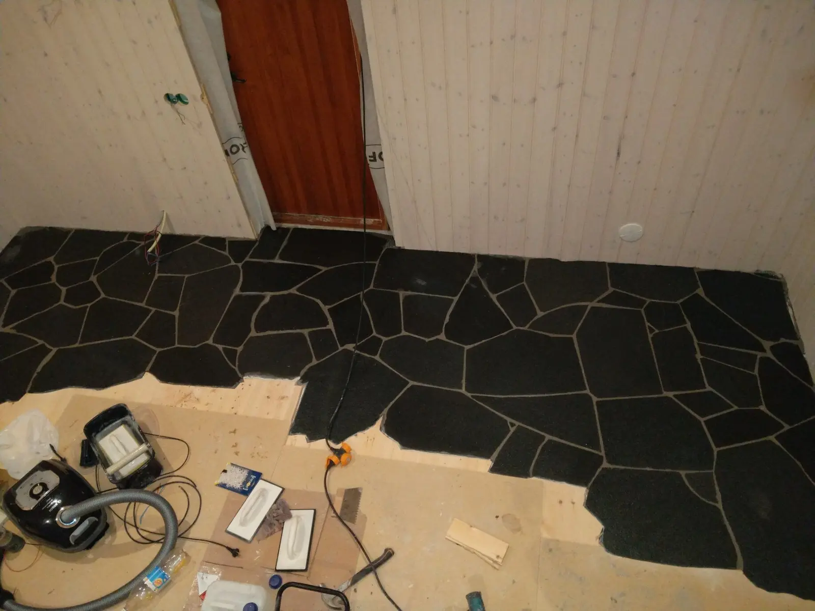 Stengolv med mörka plattor i hall.